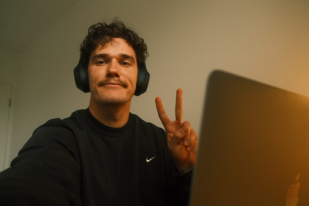 Man posing beside computer